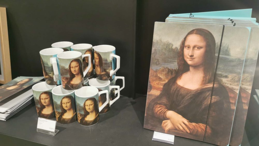 ルーヴル美術館のお土産ショップ。モナリザのイラストがプリントされたノートとマグカップ。