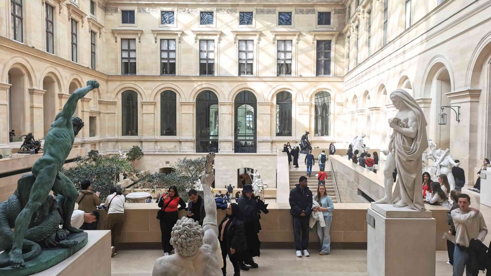 ルーヴル美術館の人気の展示室「ピュジェの中庭」。吹き抜け空間の中に彫刻が並んでいる。