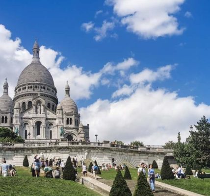 フランスのパリ、モンマルトルの丘の頂上にそびえ立つサクレ・クール寺院。白い外観が青空に映える。