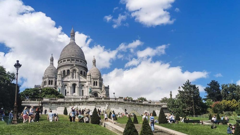 フランスのパリ、モンマルトルの丘の頂上にそびえ立つサクレ・クール寺院。白い外観が青空に映える。