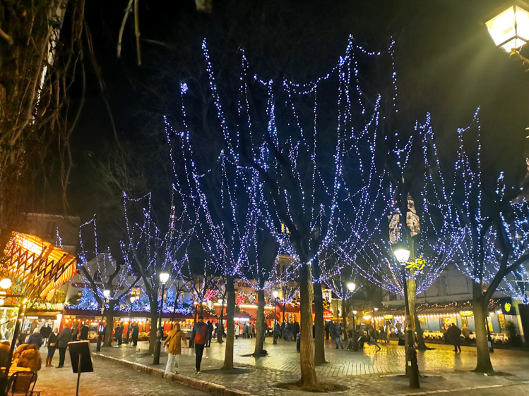 パリ、モンマルトルの丘にあるテルトル広場のクリスマスイルミネーション。広場の電飾とレストランのクリスマスイデコレーションで明るい。