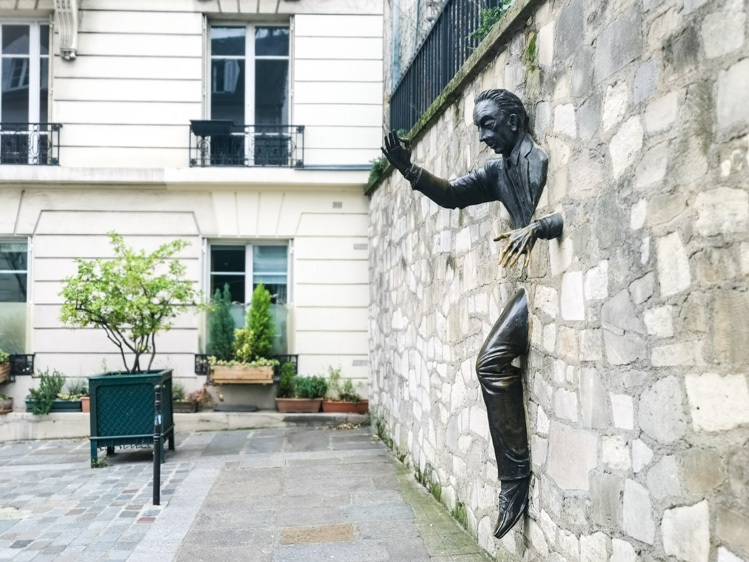 モンマルトル地区にある「壁抜け男」の銅像。壁から上半身と片足だけが飛び出ており、まさに壁を通り抜ける瞬間を捉えている。